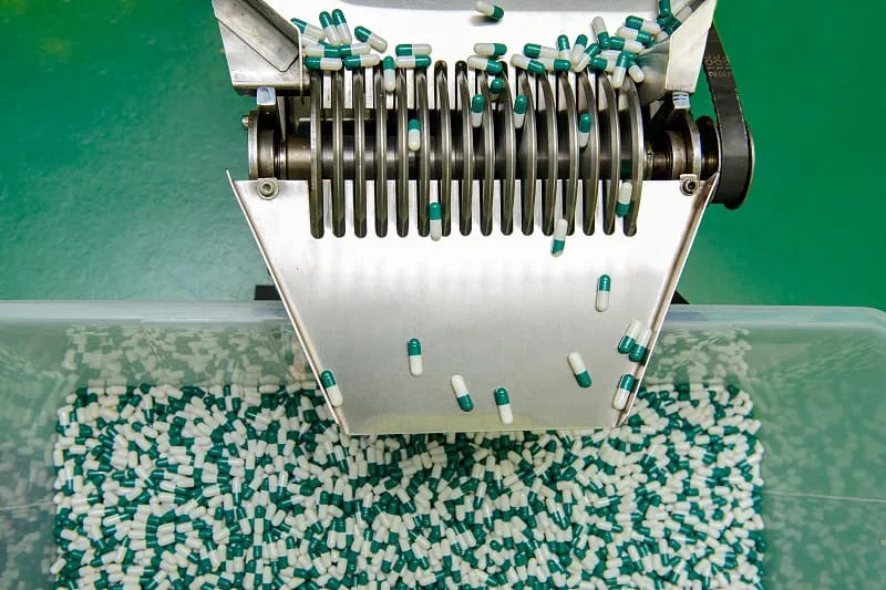Capsules leaving a filling machine on the production line